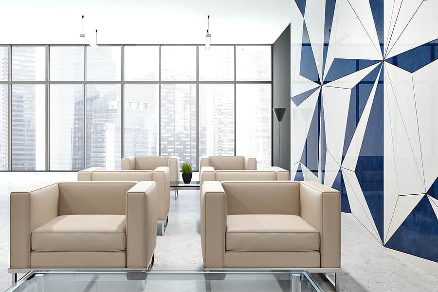 clinic bank interior with a geometric wall pattern, and rows of comfortable beige armchairs standing near a beautiful cityscape window.